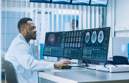 Health care worker analyzing research on a computer